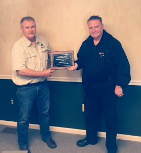 Piercy Woods, LiftMaster Representative, presents Award of Excellence plaque to Joe Karp, Micrologic Sales Engineer.